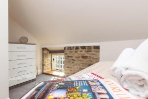 a bedroom with a bed and a stone wall at The Byre in Stanhope