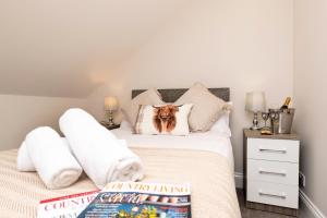 a bedroom with a bed with a dog on the pillow at The Byre in Stanhope