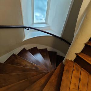 escalera de caracol de madera con ventana en un edificio en L'expérience d'Elie by Icone Collection en Caen