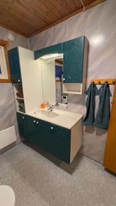 een badkamer met een wastafel en een spiegel bij Koselig hus i sentrum av Olderfjord in Russenes