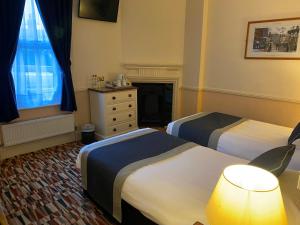 een hotelkamer met 2 bedden en een dressoir bij The Pegwell Bay Hotel in Ramsgate