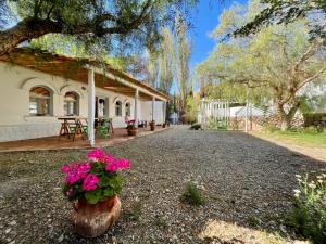 a house with flowers on the side of a driveway at Pumahuasi Hotel Boutique in Purmamarca