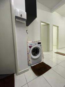 une machine à laver posée dans le coin d'une pièce dans l'établissement Hanz Homestay Melaka - For Malay Only, à Malacca