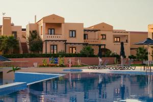 a swimming pool in front of some buildings at Silver Beach Hotel & Apartments in Gerani
