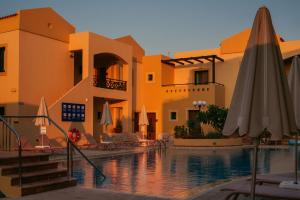 ein Hotel mit Pool mit Sonnenschirm in der Unterkunft Silver Beach Hotel & Apartments in Gerani Chania