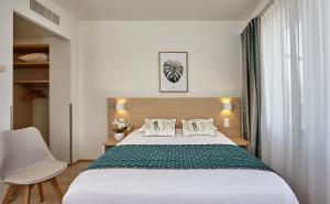 - une chambre avec un grand lit et une chaise dans l'établissement Hotel Suisse, à Genève