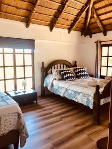 a bedroom with two beds and a wooden ceiling at Malta Homestay in José Ignacio