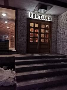 una puerta delantera de una tienda forino con escaleras delante en Fortuna Apartments, en Bansko