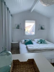 Zimmer mit 2 Betten, einem Tisch und einem Fenster in der Unterkunft Maison à 300m de la plage, quartier calme in Mimizan