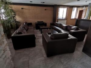 a living room with black leather couches and chairs at Fortuna Apartments in Bansko