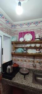 cocina con encimera con platos y fregadero en Casa Lotfi, en Chefchaouen