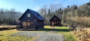 チスナにあるMagiczne Bieszczady - Krzywe 24の草原に2軒の家が建っている