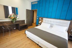 um quarto com uma cama grande e uma parede azul em Hotel Concord em Turim
