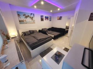ein Wohnzimmer mit einem Bett und einem Sofa in der Unterkunft Miami Apartment in Paderborn