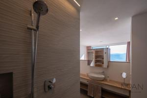 La salle de bains est pourvue d'une douche, d'un lavabo et d'un miroir. dans l'établissement Noan Panorama Suiten - Arendt, à San Genesio Atesino