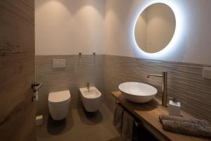 bagno con lavandino, servizi igienici e specchio di Noan Panorama Suiten - Arendt a San Genesio Atesino