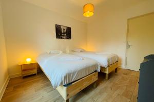 two twin beds in a room with two lamps at The House of the Green Way a charming pied-à-terre for your walks in Toura in Joue-les-Tours