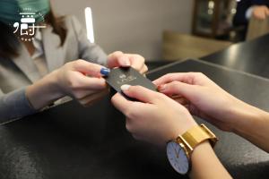 a woman holding a cell phone in her hands at Aroma Chew Hotel in Taichung