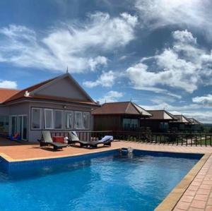 a house with a swimming pool in front of a house at Sumeru in Sen Monorom
