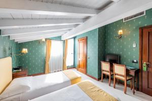 a bedroom with a bed and a desk and a television at Hotel Du Lac Menaggio in Menaggio