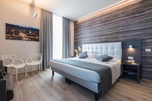 een slaapkamer met een groot bed en een houten muur bij Hotel Concord in Turijn