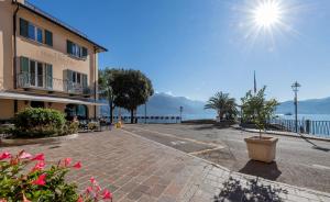 an empty street next to a building with a view of the water at Hotel Du Lac Menaggio in Menaggio