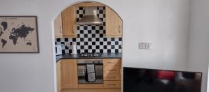 a kitchen with wooden cabinets and a stove top oven at The Gateway Guest Apartment in Portstewart
