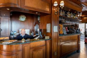 un homme assis dans un bar dans un pub dans l'établissement Hotel Du Lac Menaggio, à Menaggio