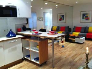 a kitchen and living room with a table and a couch at Into Paris - Louvre Apartment in Paris