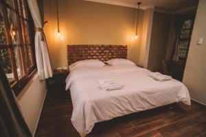 a bedroom with a large bed with towels on it at KANTU GARDEN LODGE in Moyobamba