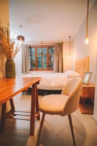 a bedroom with a bed and a desk and a chair at KANTU GARDEN LODGE in Moyobamba