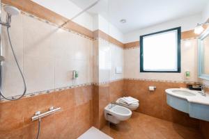 a bathroom with a toilet and a sink and a shower at Hotel Du Lac Menaggio in Menaggio