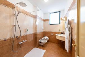 een badkamer met een douche, een toilet en een wastafel bij Hotel Du Lac Menaggio in Menaggio +37 foto's
