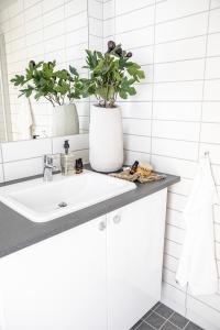 łazienka z umywalką i 2 doniczkami w obiekcie Wex Hotels w mieście Fredrikstad