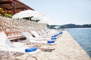 a row of chairs sitting on top of a beach at Hotel Odisej in Goveđari