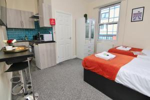 a small bedroom with a bed and a kitchen at Charming Studio 2 mins Walk To Belgrade Theatre in Coventry