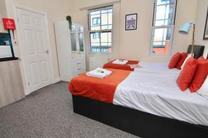 een slaapkamer met 2 bedden en rode kussens bij Charming Studio 2 mins Walk To Belgrade Theatre in Coventry