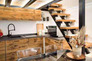 a kitchen with wooden cabinets and a spiral staircase at Mon Petit Cervin in Valtournenche