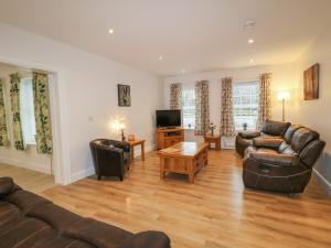 a living room with leather couches and a television at Sliabh Amharc in Downpatrick