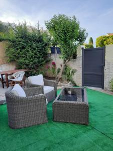 een patio met stoelen en een vuurplaats op groen gras bij Rêves de vie Studio Morgiou avec terrasse et parking privé in Cassis