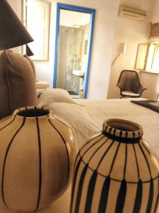 zwei schwarze und weiße Vasen auf einem Bett in der Unterkunft Casa Don Michele in Letojanni