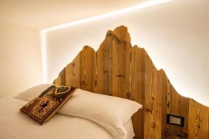 un letto con testiera in legno e cuscino di Mon Petit Cervin a Valtournenche