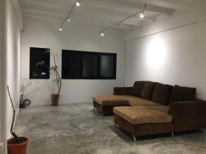 a living room with a couch and a flat screen tv at เจริญพาณิชย์ รูมส์ in Pathum Thani