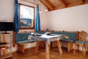 a living room with a blue couch and a table at Apt Talblick Hinterproslhof in Sarntal