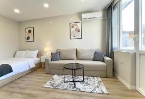 a bedroom with a bed and a couch and a table at Elegant Studio for 4 Guests in City Center in Stara Zagora
