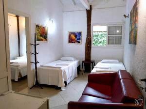 ein Zimmer mit 2 Betten und einem Sofa darin in der Unterkunft Pousada Baobá in Juquei