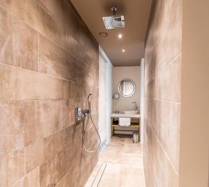ein Bad mit einer Dusche und einem Waschbecken in der Unterkunft Villa Noordzee in Renesse