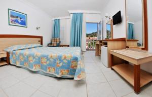 A television and/or entertainment centre at Ölüdeniz Turquoise Hotel - All Inclusive