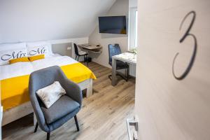 a bedroom with a bed and a chair and a desk at Apartmaji Pr Smolet in Škofja Loka