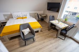 a bedroom with a bed and a chair and a table at Apartmaji Pr Smolet in Škofja Loka
